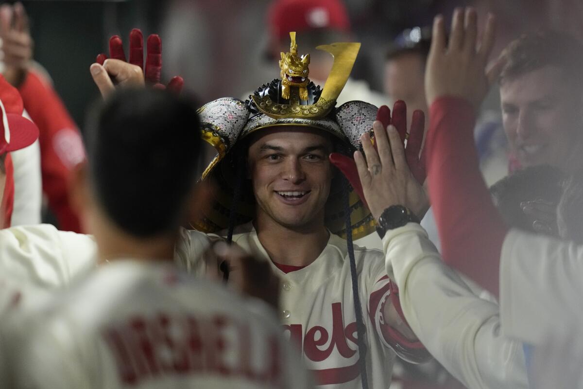 Angels' Logan O'Hoppe wears a kabuto while celebrating in the dugout after hitting a home run.