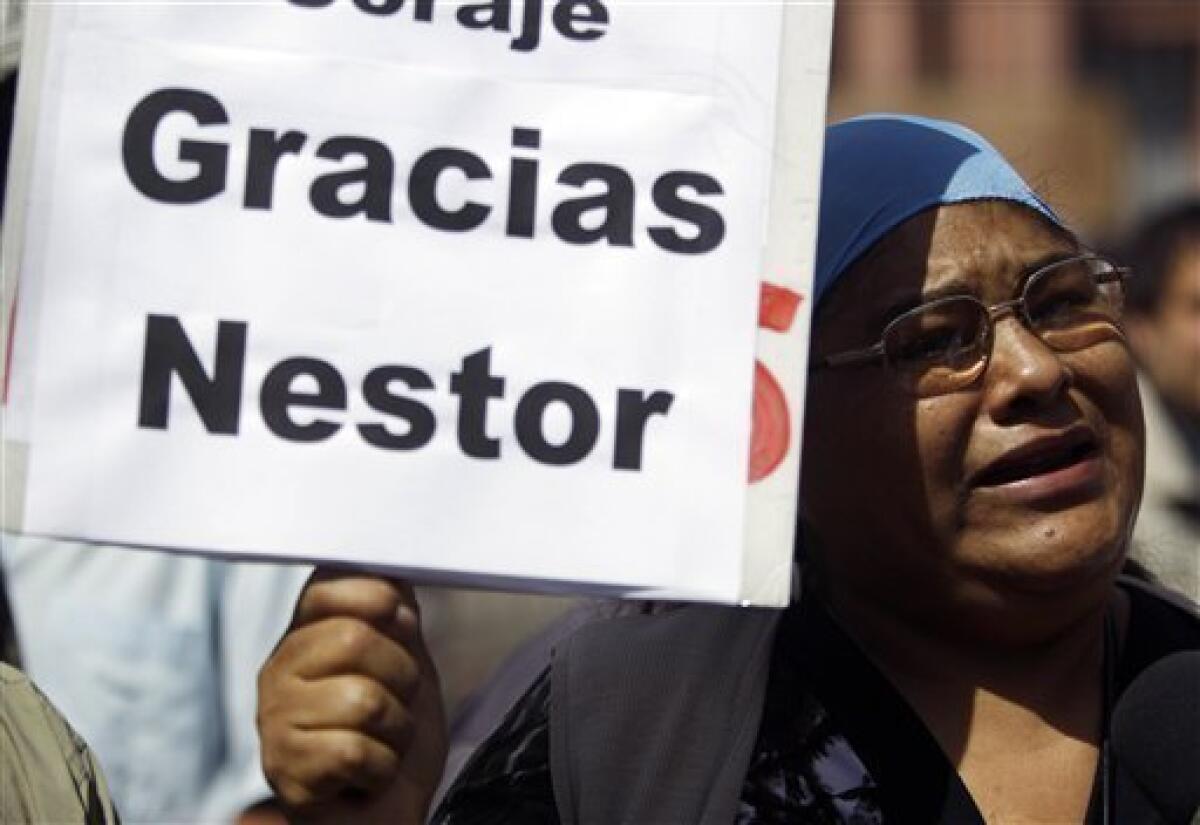 A woman holds a sign that reads in Spanish "Thanks Nestor" outside the government palace in Buenos Aires, Argentina, Wednesday Oct. 27, 2010. Argentina's former President Nestor Kirchner, who served as president from 2003-2007, died Wednesday after suffering heart attacks at age 60. (AP Photo/Natacha Pisarenko)