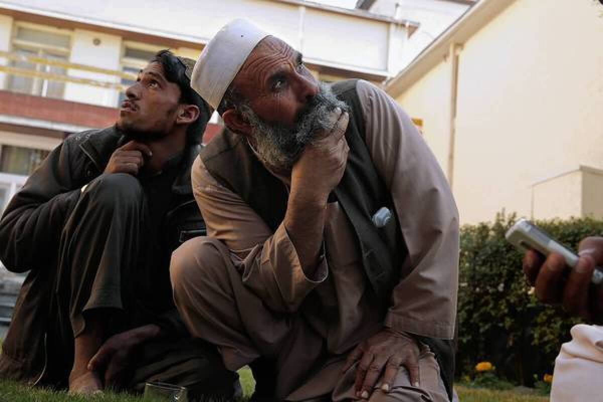 Abdul Ghafar, left, and Rahmat Gul, who both lost relatives in a U.S. drone attack in their Afghan village Sept. 7, watch as a U.S. drone flies over the city of Jalalabad.