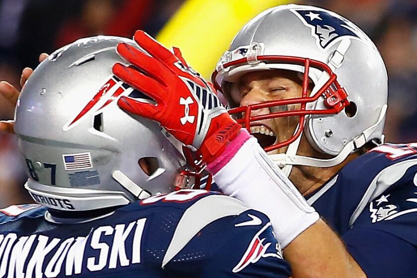 New England Patriots quarterback Tom Brady, right, celebrates with teammate Rob Gronkowski after scoring a touchdown during a win over the Cincinnati Bengals.