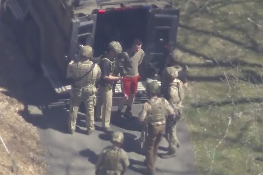 An image taken from video shows Jack Teixeira, 21, being taken into custody  in Dighton, Mass.  