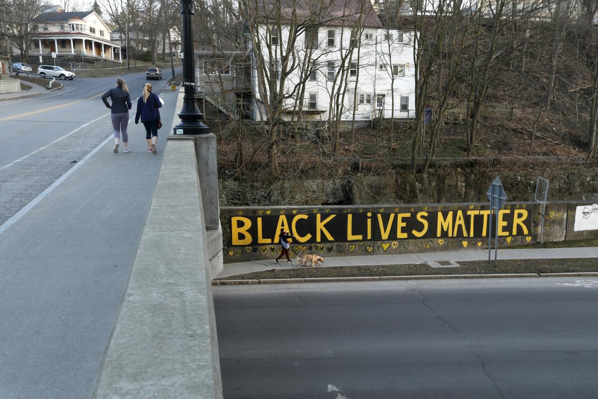 Black Lives Matter is seen along East Green Street where is passes under South Aurora Street, Monday, March 22, 2021, in Ithaca, N.Y. The nationwide reexamination of policing after the killing of George Floyd has led the Ivy League town in New York to consider an ambitious and contentious plan to remake its force. A proposal would replace the 63-officer Ithaca Police Department with a new Department of Community Solutions and Public Safety. (AP Photo/John Munson)