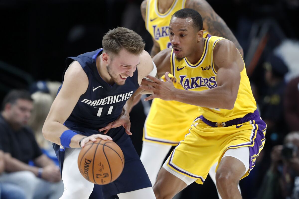 Lakers guard Avery Bradley defends Mavericks guard Luka Doncic during game earlier this season.
