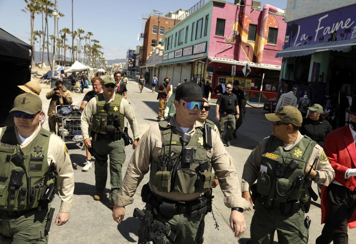 Los Angeles County sheriff's deputies patrol Ocean Front Walk in Venice to assess the homeless situation on June 8. 