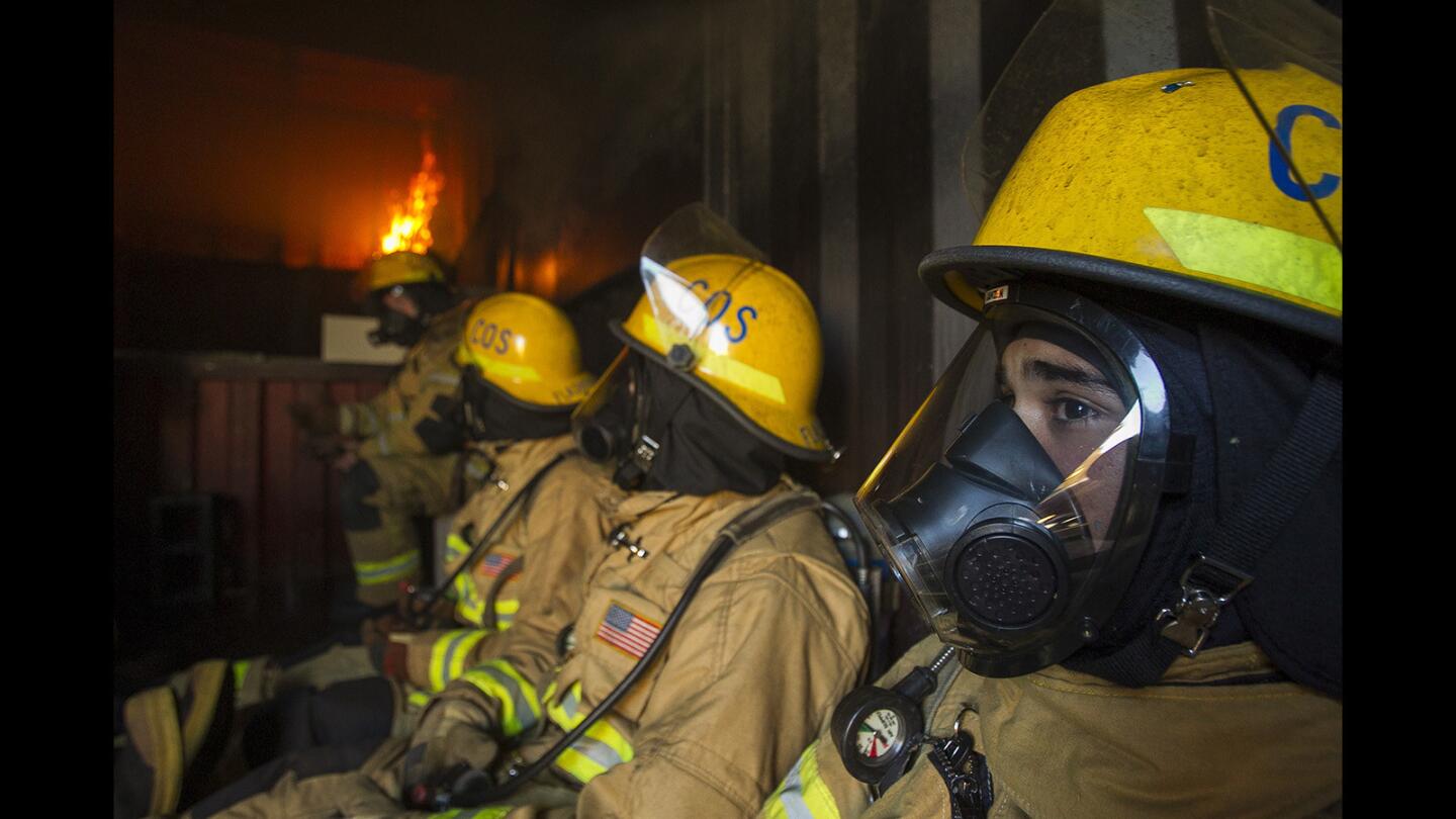Newly hired firefighters go through a live burn training exercise in a flashover container during a six-week fire academy run by the Costa Mesa Fire Department on Wednesday, March 29.