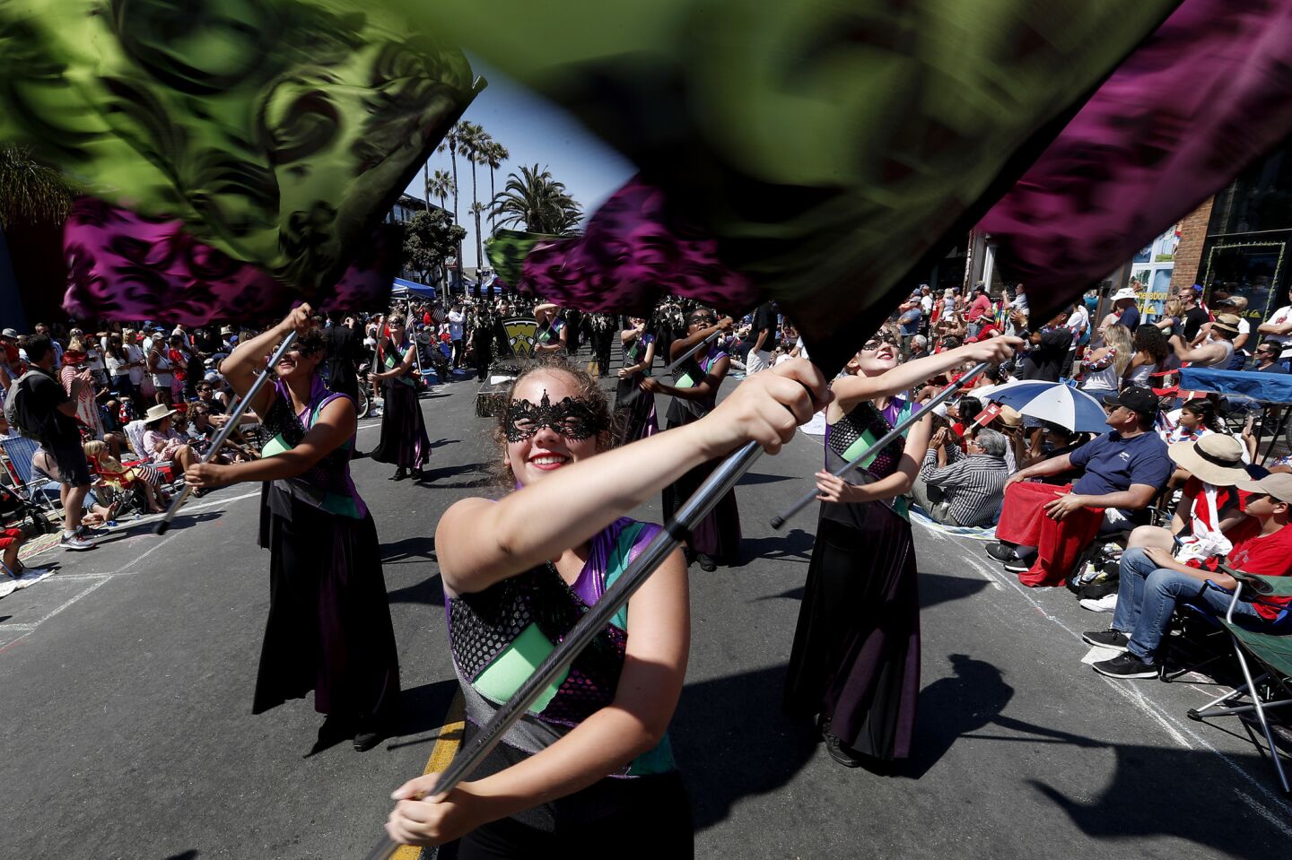 A flag team from Waconia (Wis.) High School performs on Main Street during the annual Independence Day Parade in Huntington Beach.