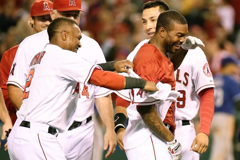 Howie Kendrick, center, drove in Josh Hamilton with a double in the bottom of the 10th inning to give the Angels their 40th win of the season.