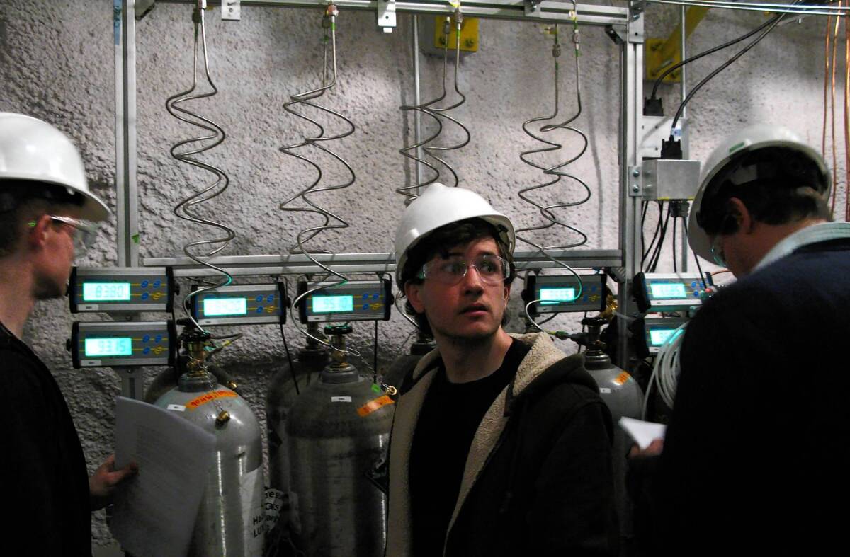 From left, graduate students Patrick Phelps and Richard Knoche and Yale University physicist Dan McKinsey release compressed xenon to be used in the LUX detector in a former South Dakota gold mine.