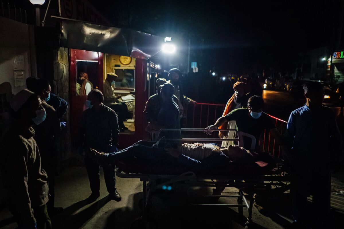 A person wounded in the Kabul airport bombing is brought by an ambulance to a hospital