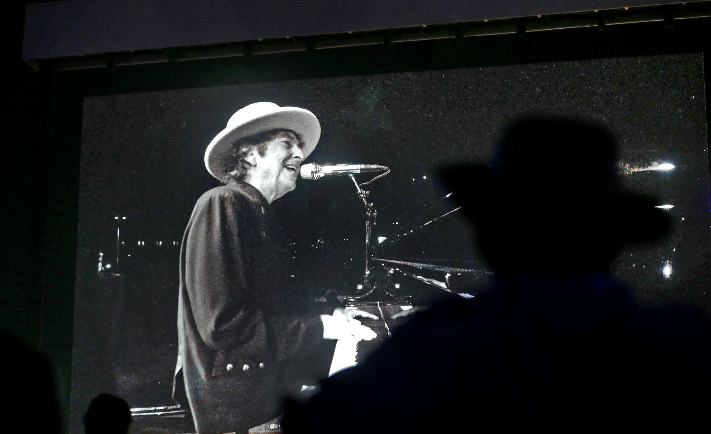 A fan is silhouetted as he watches Bob Dylan perform on the big screen on the first day of the three-day Desert Trip at the Empire Polo Club grounds in Indio.