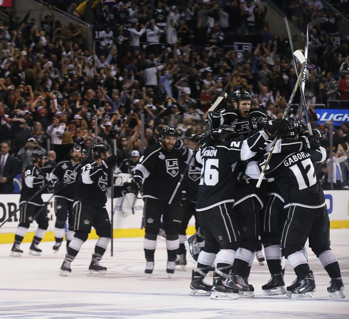 Kings teammates swarm Willie Mitchell, who initiated the winning score in double overtime Saturday night against the New York Rangers.