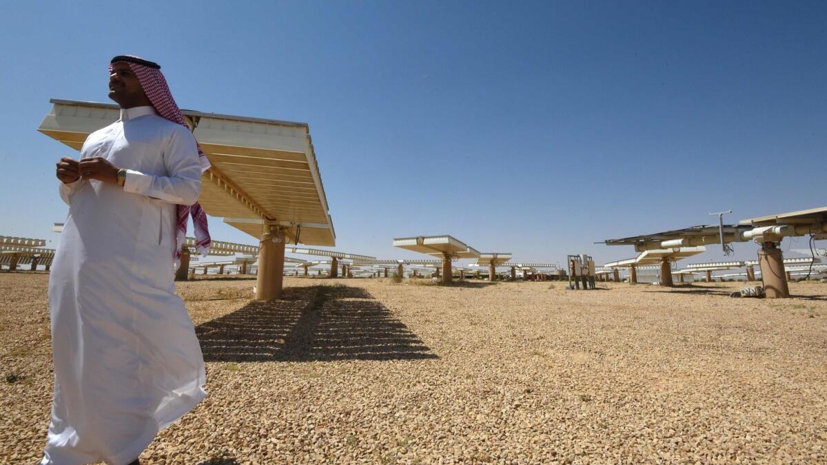 A Saudi man stands at a solar plant in Uyayna, north of Riyadh, in March.