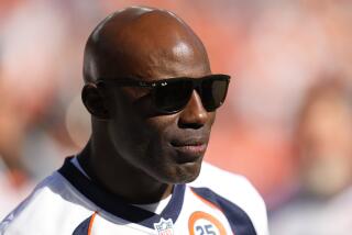 Former Denver Broncos running back Terrell Davis wears shades looks on during a half time ceremony at an NFL football game
