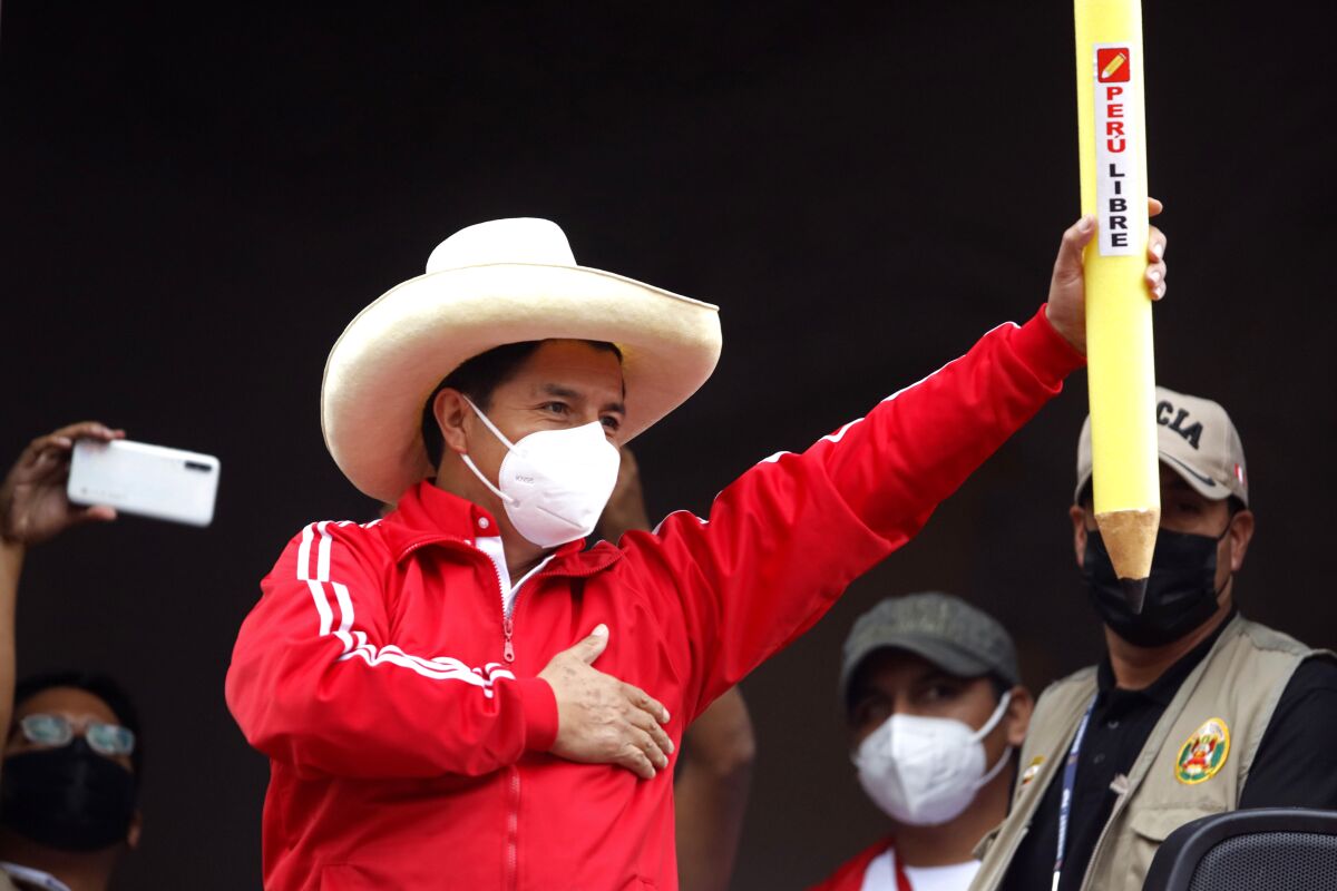 Pedro Castillo holds up a large, mock pencil during his closing campaign rally in Lima, Peru.