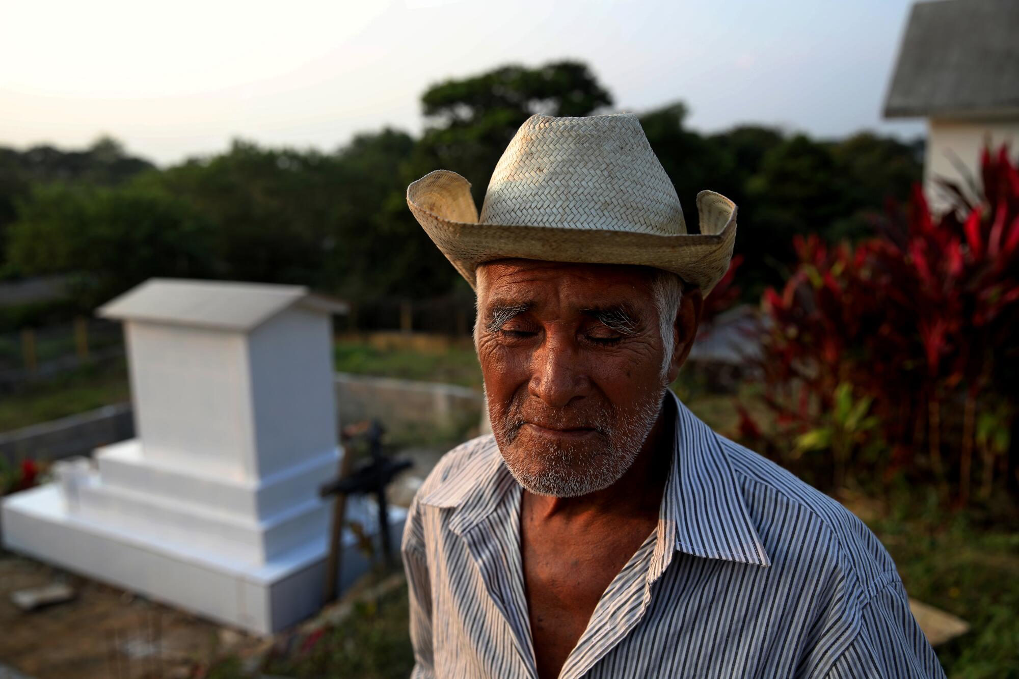 A man stands in a cemetery.
