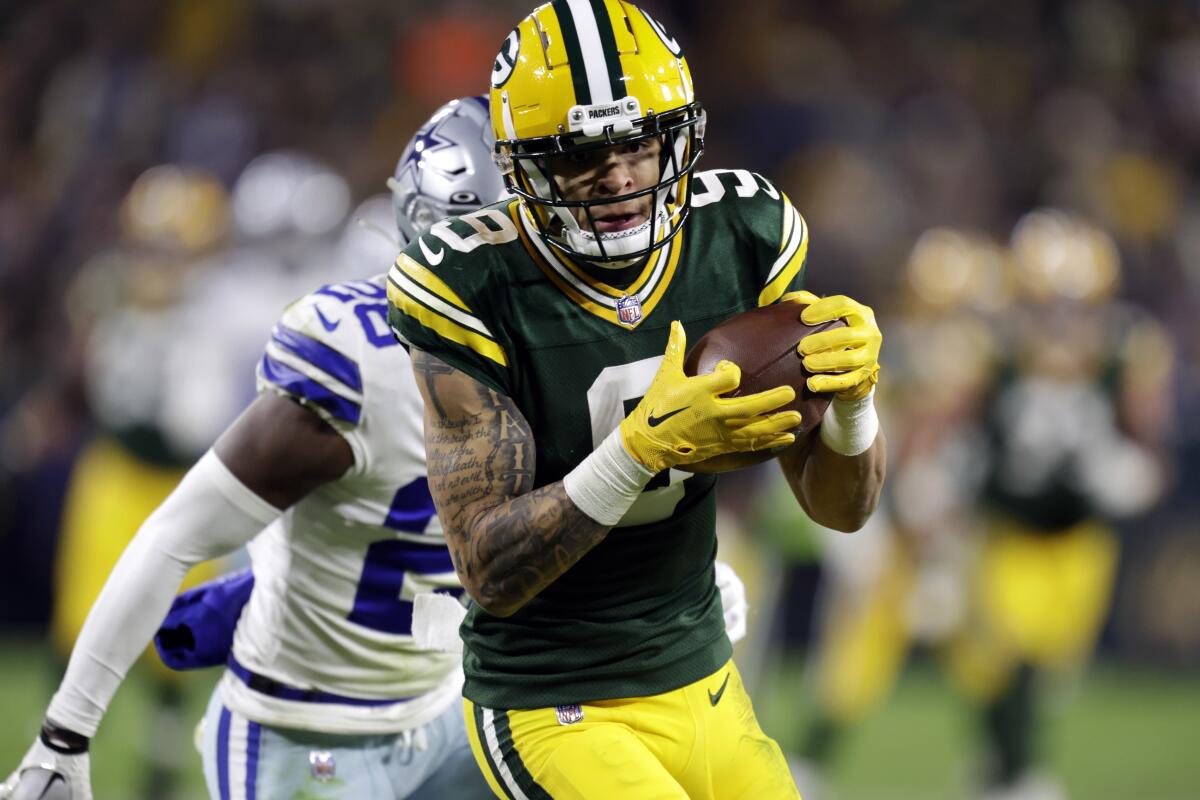 Green Bay Packers wide receiver Christian Watson catches a pass for a touchdown in front of safety Darnell Savage.