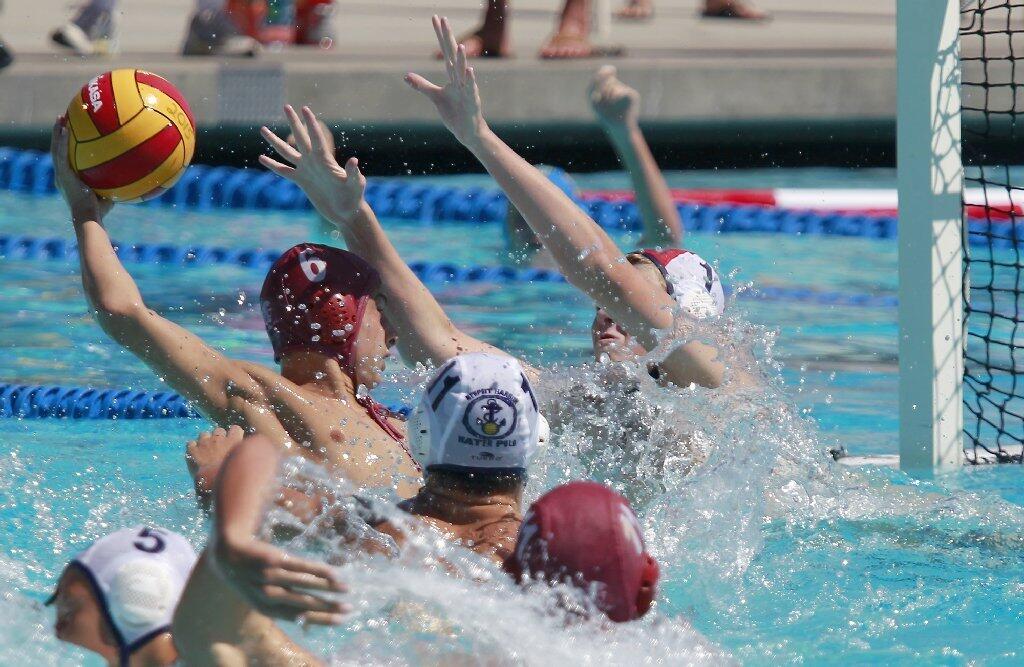 Goalkeeper Cal Meyer, right, of Newport Beach Water Polo is unable to stop Stefan Vavic (6) of Trojan from scoring the go-ahead goal during the fourth period in the USA Junior Olympics 14U boys' bronze match at the William Woollett Aquatic Center in Irvine on Tuesday.