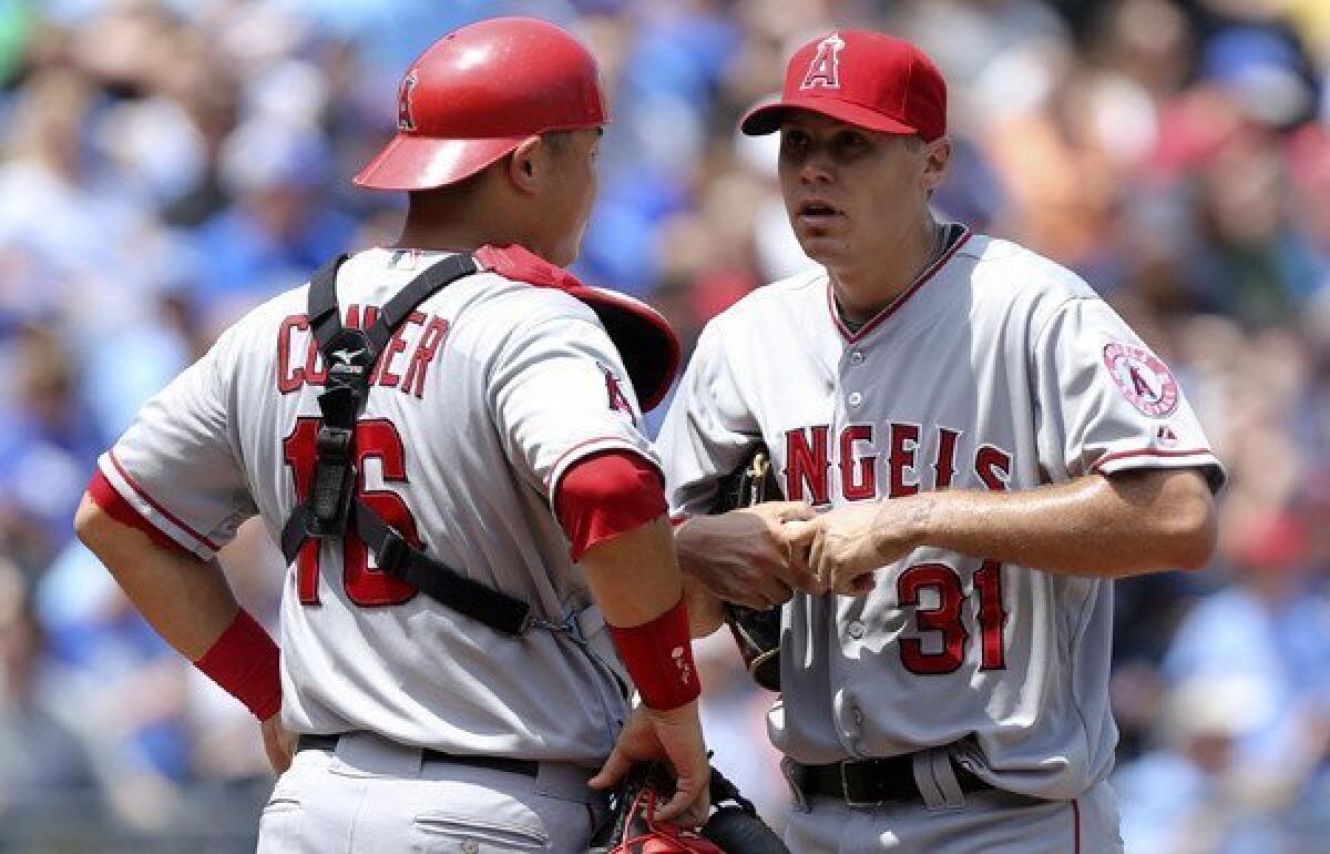 Angels catcher Hank Conger talks to pitcher Billy Buckner during the fifth inning Saturday at Kansas City.