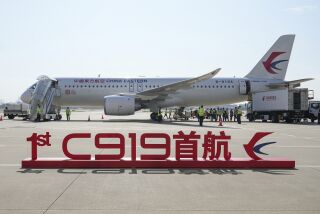 En esta imagen publicada por la agencia de noticias Xinhua, un cartel que dice "Vuelo inaugural del primer C919" se ve ante un avión de pasajeros de fabricación china, antes de su primer trayecto comercial desde Shanghái, el domingo 28 de mayo de 2023. (Ding Ting/Xinhua via AP)