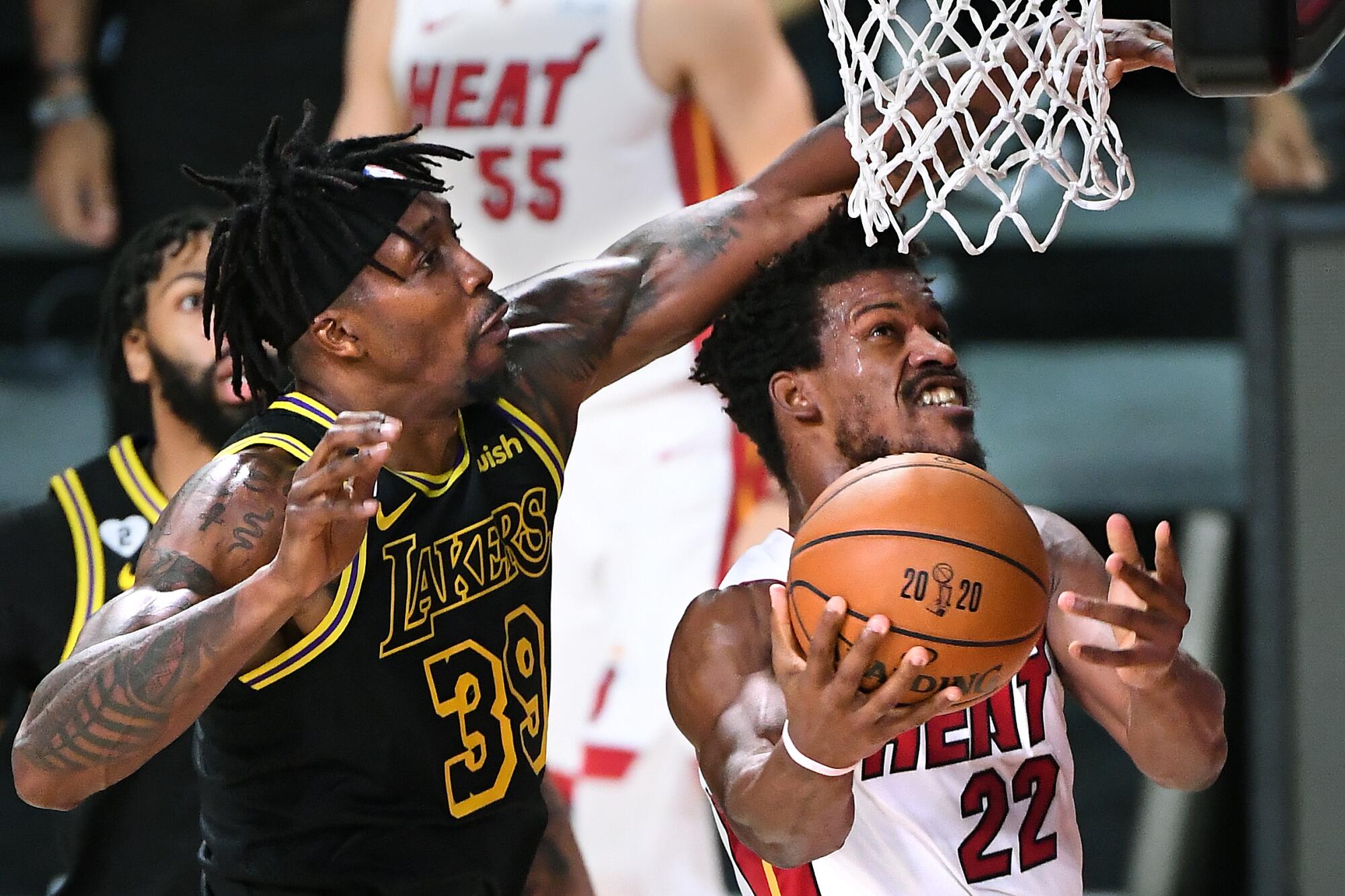 Lakers center Dwight Howard fouls Miami Heat forward Jimmy Butler as he drives to the basket.