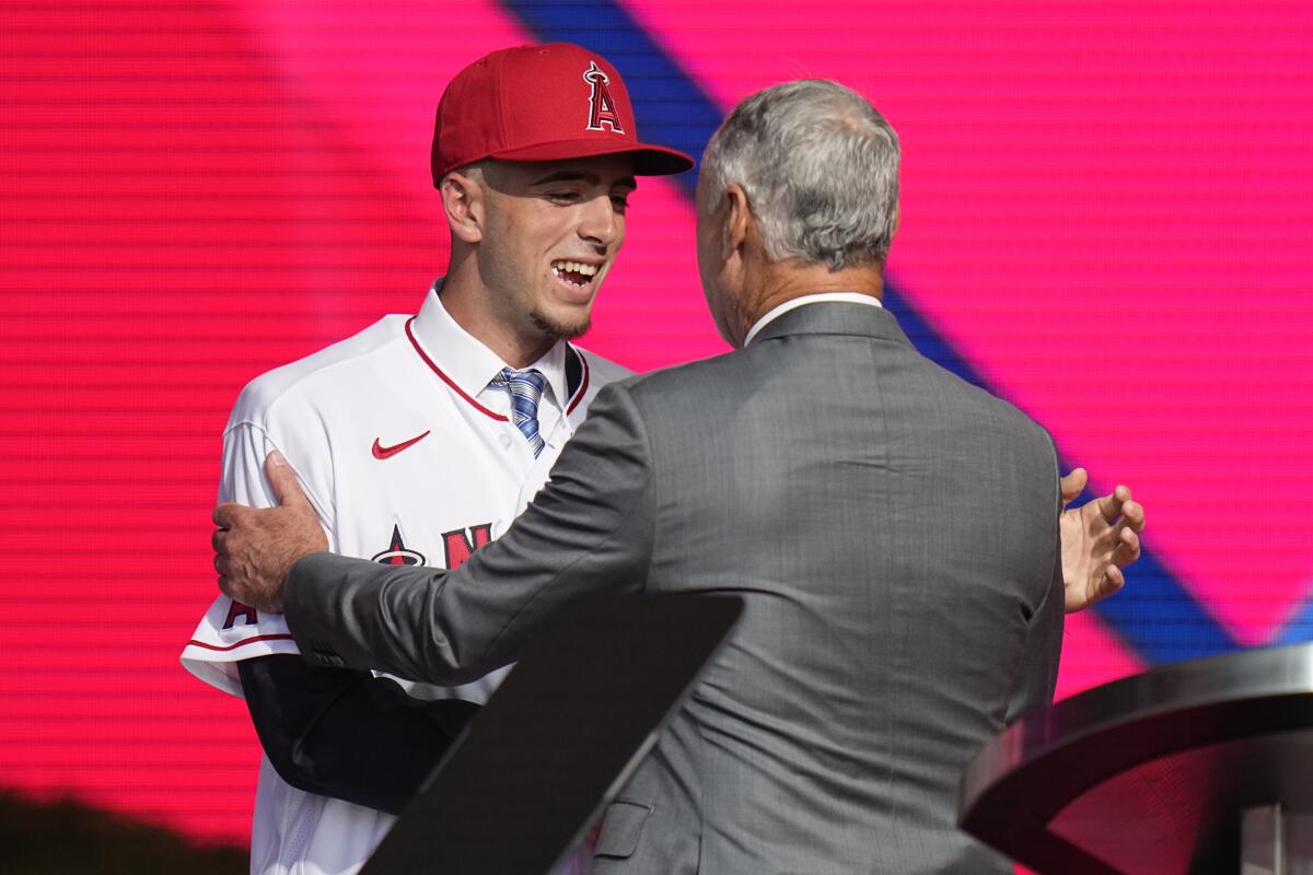 Zach Neto, left, shakes hands with MLB Commissioner Rob Manfred.