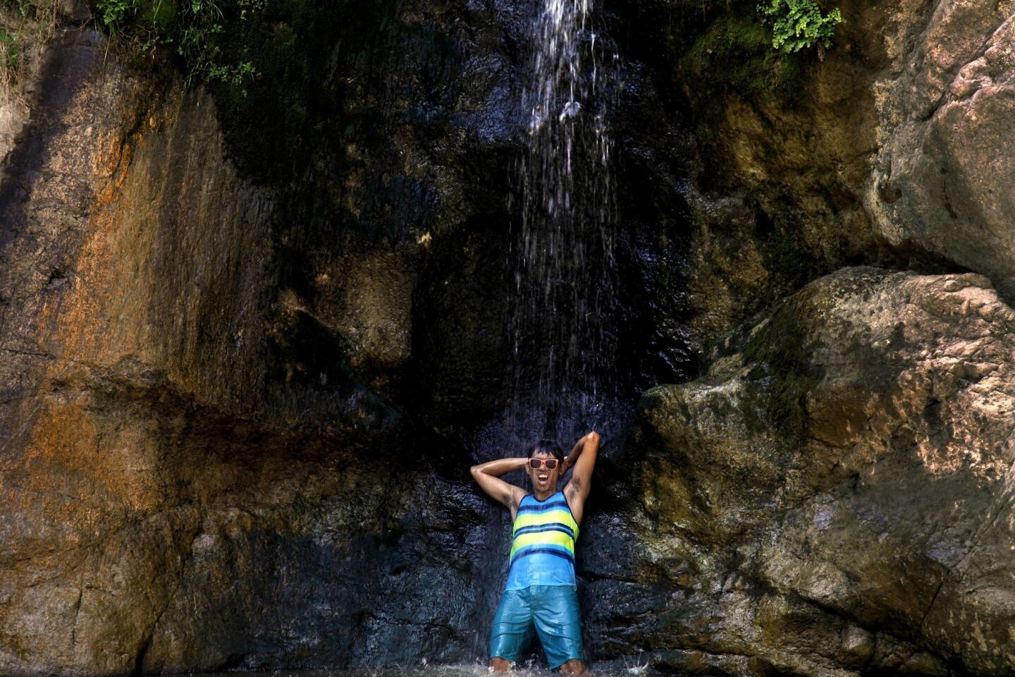 Cholo Inciong, 24, of Los Angeles, revels in the water at the base of Eaton Canyon Falls.