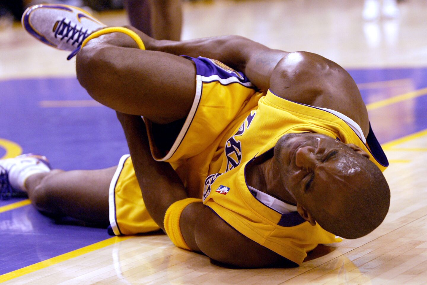 Kobe Bryant down on the court, clutching his right ankle.