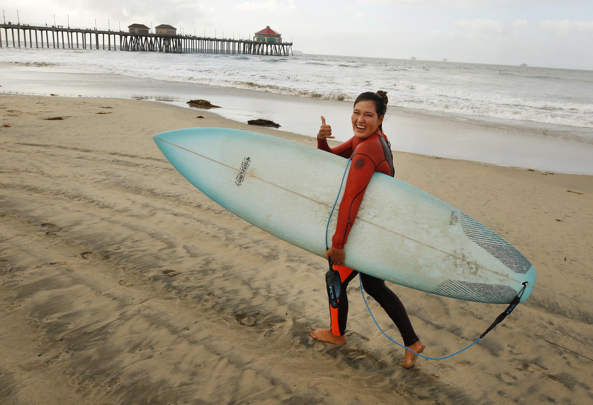 Monica Dunn, of Huntington Beach, is all smiles as she joins the first surfers back into the water