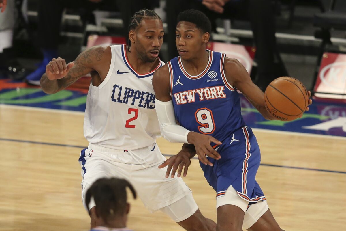 New York Knicks shooting guard R.J. Barrett has the ball while Clippers forward Kawhi Leonard guards him.
