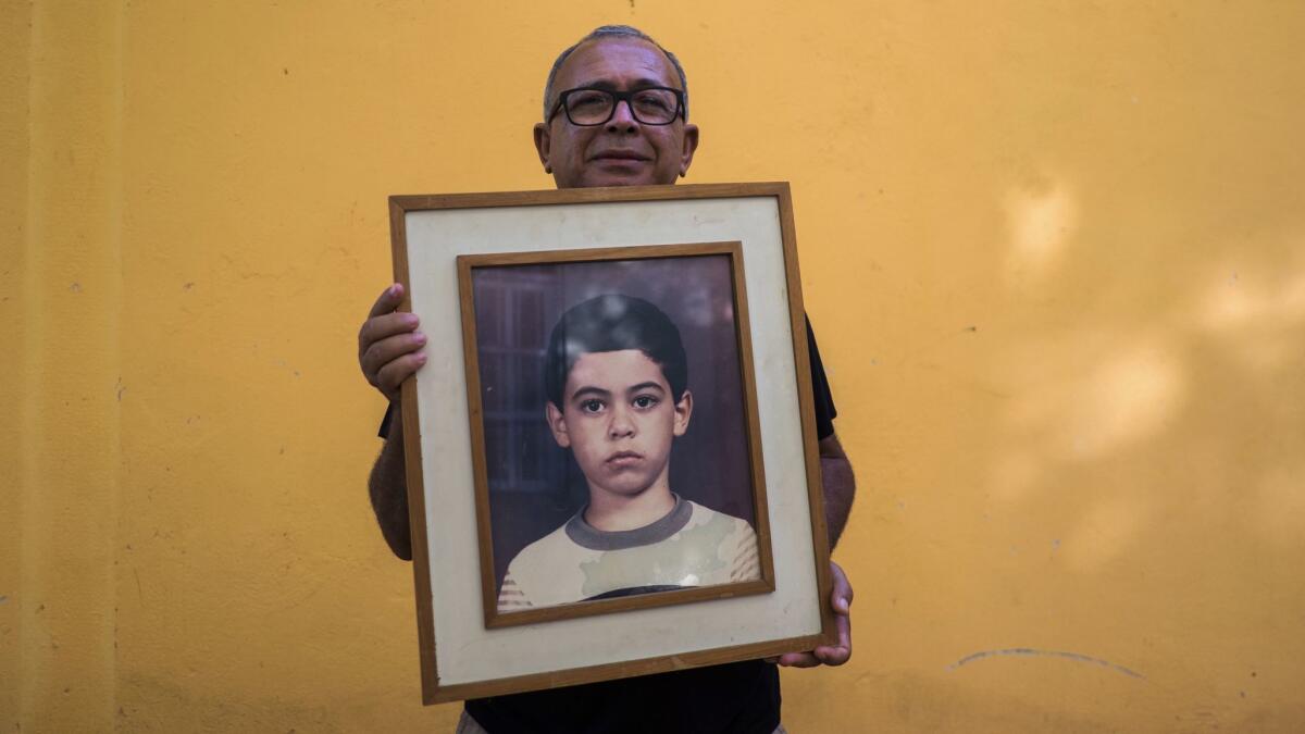 Francisco Luiz da Silva holds a photo of his son Guilherme Figueiredo da Silva, who disappeared after the riot at Alcacuz State Penitentiary.