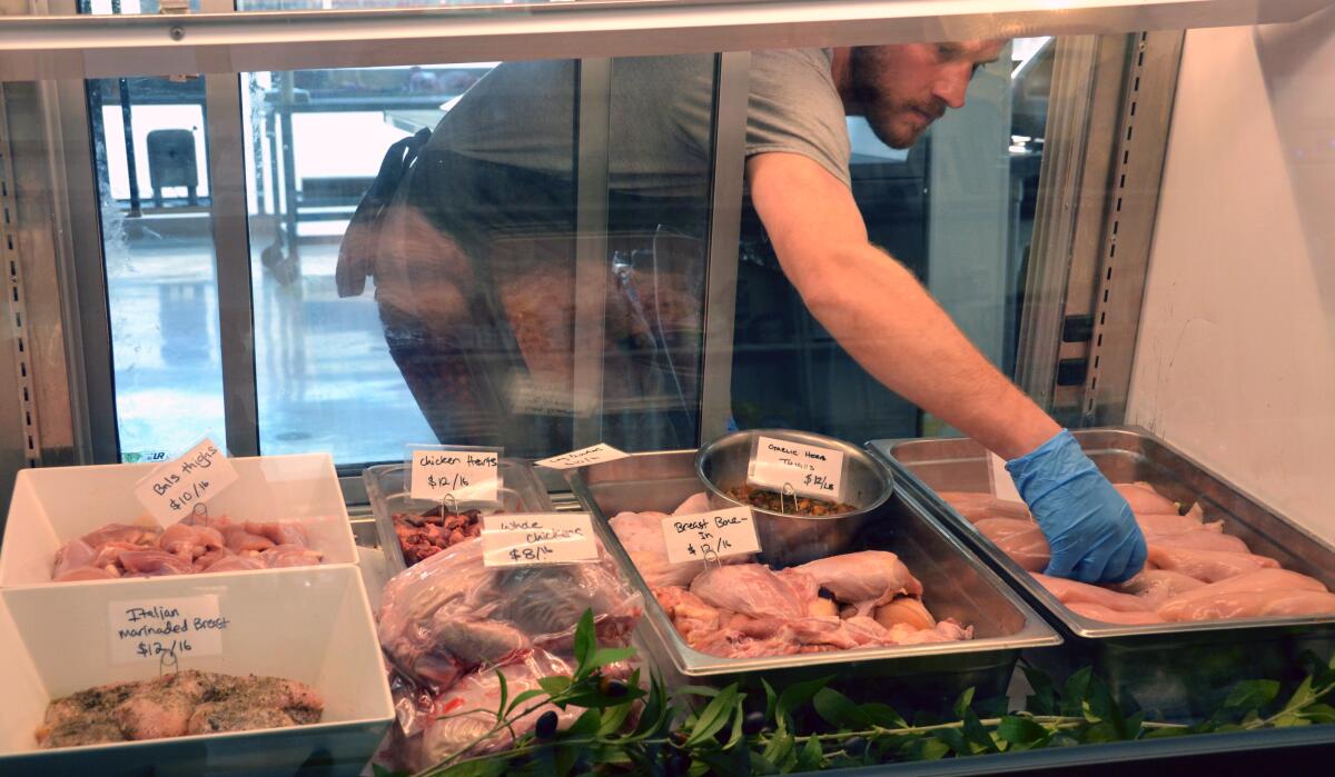Butcher Joe Vitale arranges fresh-cut and whole chickens at Sections Fine Meats.