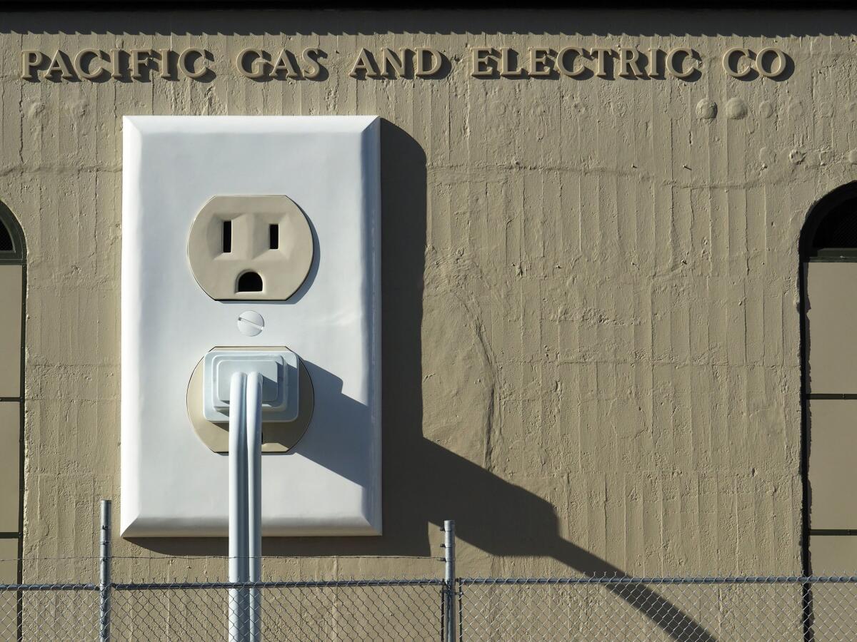 An art installation titled 'Outlet-plug-cord' (2015) by Basal Ganglia Studio is displayed on the side of a Pacific Gas & Electric substation in Petaluma, Calif., in July 2015.