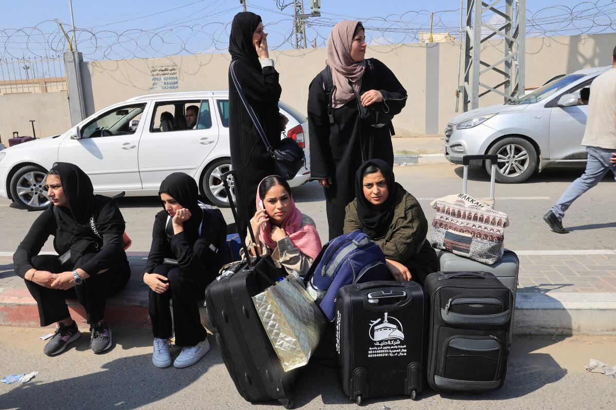 Palestinians with foreign passports wait at the Rafah gate hoping to cross into Egypt.
