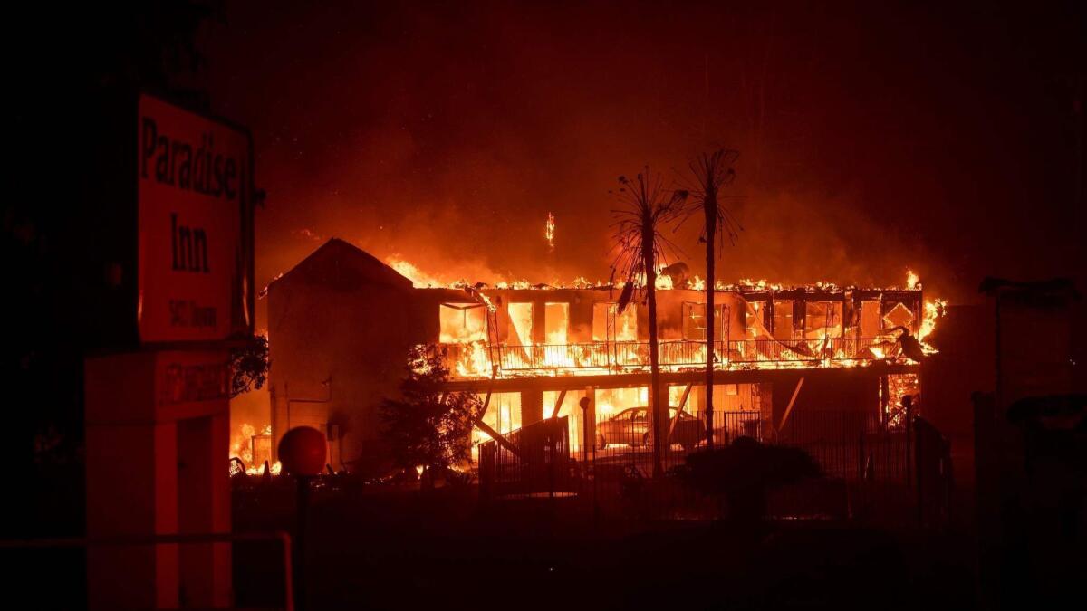 A hotel burns on Nov. 9, 2018, as the Camp fire tears through Paradise, Calif. Potential liabilities from the blaze effectively push PG&E to file for bankruptcy.