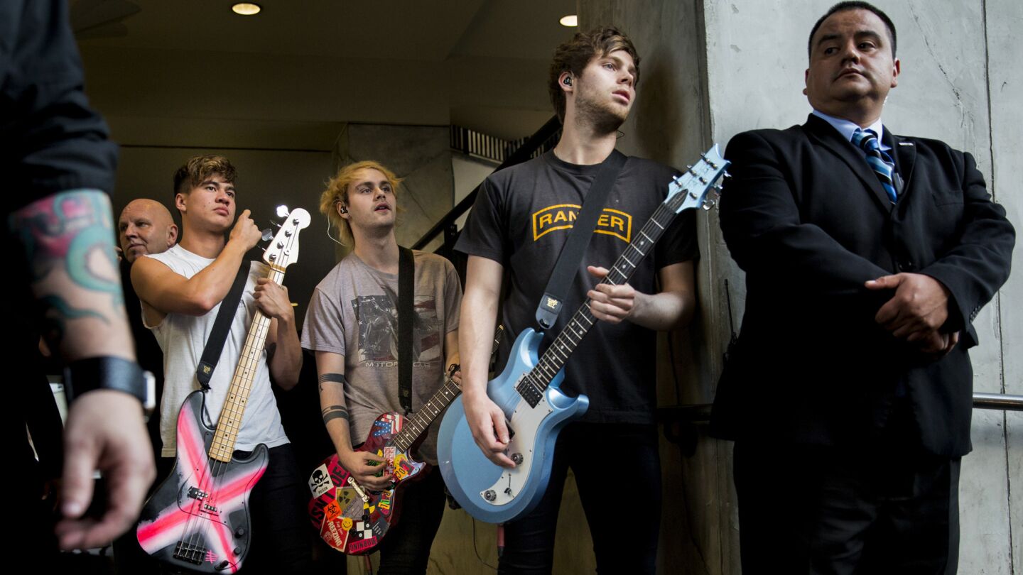 Australian pop band 5 Seconds of Summer members Calum Hood, left, Michael Clifford, and Luke Hemmings backstage before their performance at Hollywood & Highland Center Oct. 23, 2015.