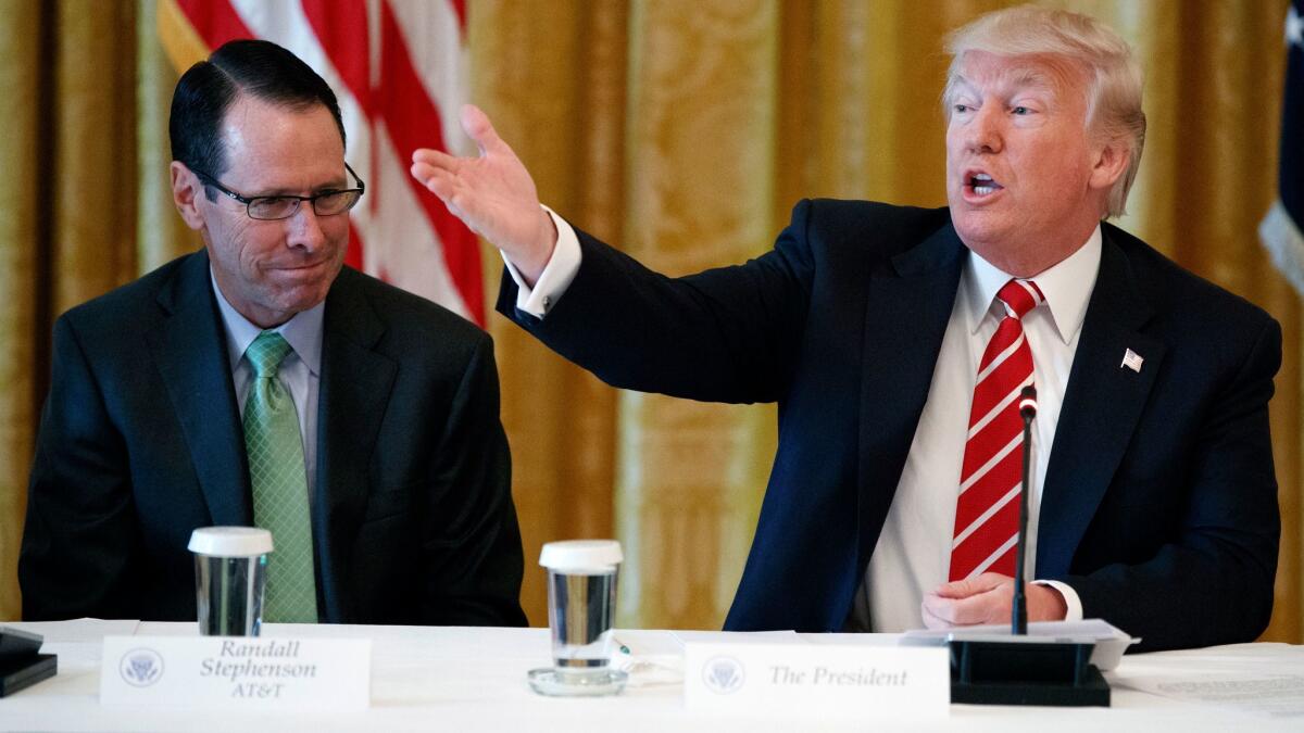 AT&T CEO Randall Stephenson, left, listens while President Trump speaks during the American Leadership in Emerging Technology event at the White House on June 22.