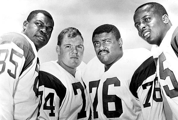 This photograph from 1964 shows the Los Angeles Rams' legendary defensive line known as the "Fearsome Foursome." From left: Lamar Lundy (85), Merlin Olsen (74), Rosey Grier (76) and Deacon Jones (75).