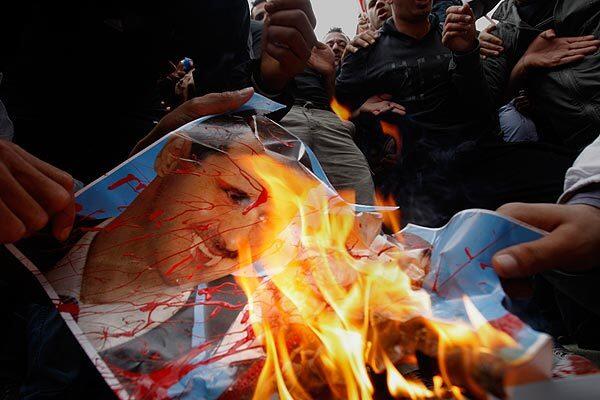 Syrian protesters burn a poster of President Bashar Assad during a demonstration in front of the Syrian Embassy in Nicosia, Cyprus. Several hundred Syrian protesters in Cyprus have called for Assad's resignation.