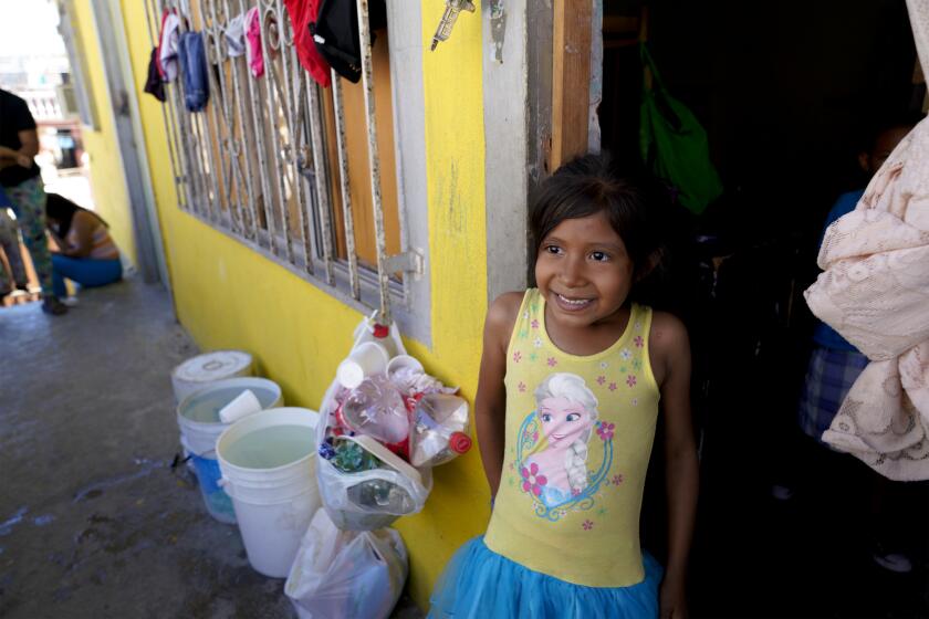 Fernanda Martinez, 6 from Honduras stands at the doorway to the room where she and her mother, Jasmine Marinez, 34 were quarantined to because they had chicken pox. As of August 15th the two are free to move about the shelter at the Agape World Mission shelter in Tijuana, Mexico.