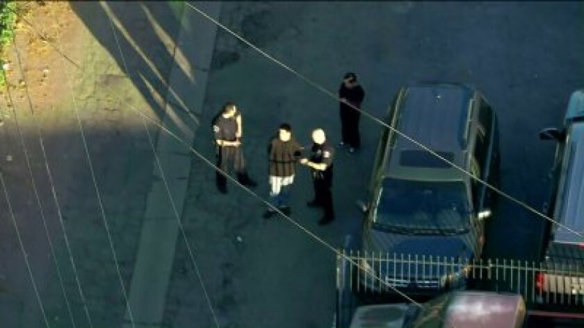 Police talk to a person in the Lake Balboa area while investigating a stabbing near Mulholland Middle School on Thursday.