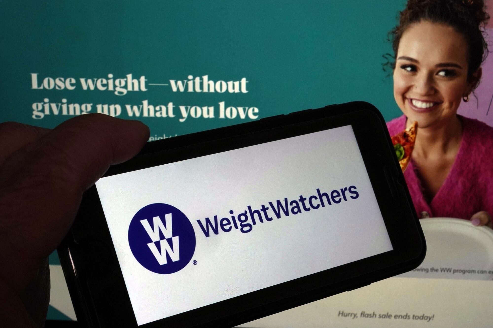Logo of WeightWatchers on a mobile phone, and the company's website, in New York, Tuesday, March 7, 2023.