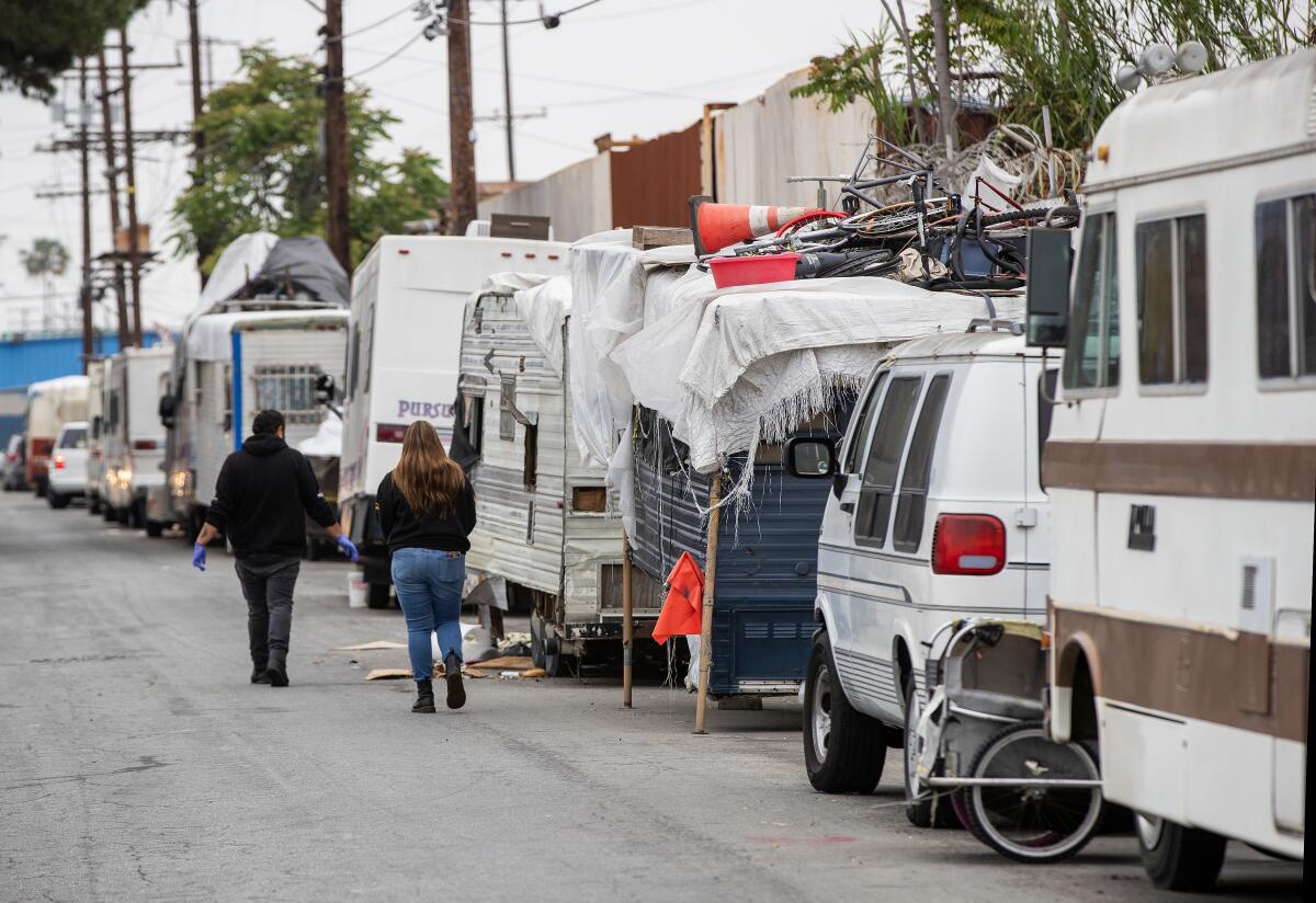 Outreach workers at a homeless RV encampment along 77th Street in South Los Angeles.