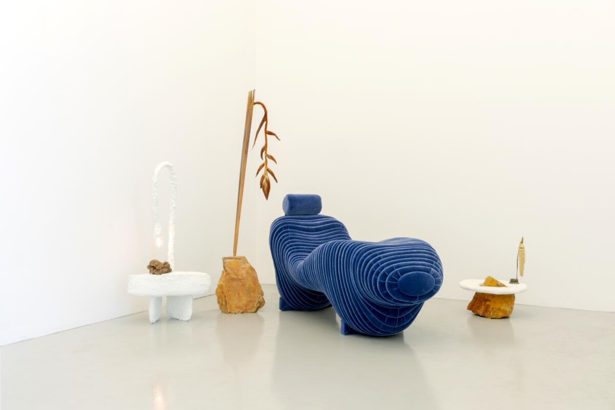 An abstract blue chair surrounded by sculptures. 