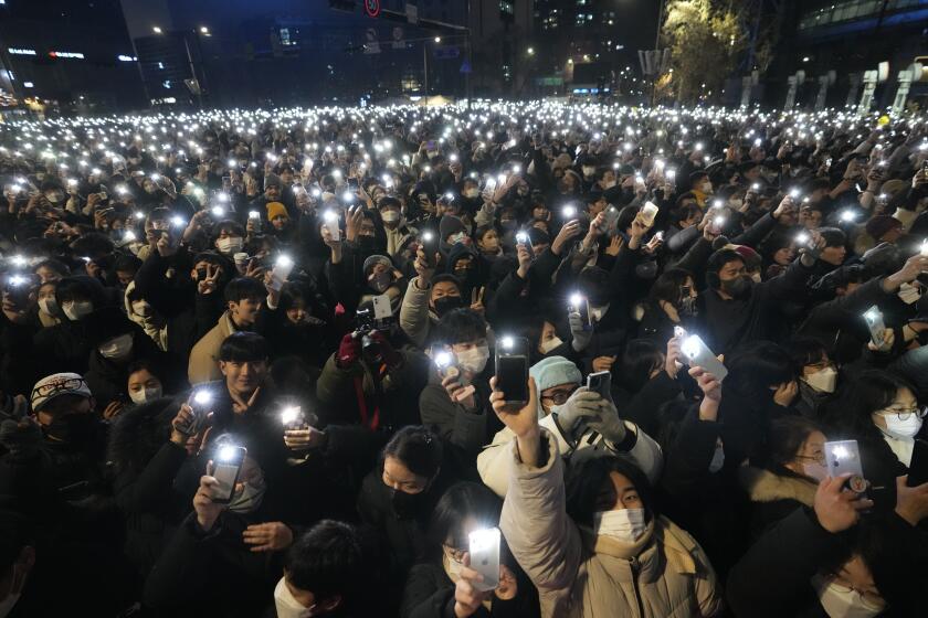 People light up their smartphones as they celebrate the New Year's eve in front of the Bosingak pavilion where its annual New Year's bell-ringing ceremony is held in Seoul, South Korea, Saturday, Dec. 31, 2022. (AP Photo/Lee Jin-man)