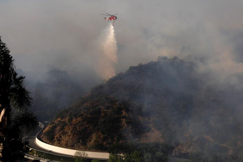 BRENTWOOD CA OCTOBER 28, 2019 -- A helicopter makes a drop on the Getty fire, which was threatening thousands of homes in Brentwood and other hillside communities on the west side of Los Angeles Monday morning, October 28, 2019. (Gray Coronado / Los Angeles Times)