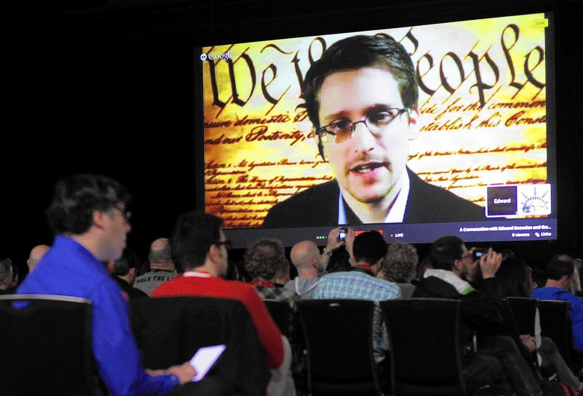 Former National Security Agency contractor Edward Snowden speaks remotely to the South by Southwest Interactive conference in Austin, Texas, superimposed over an image of the Constitution.