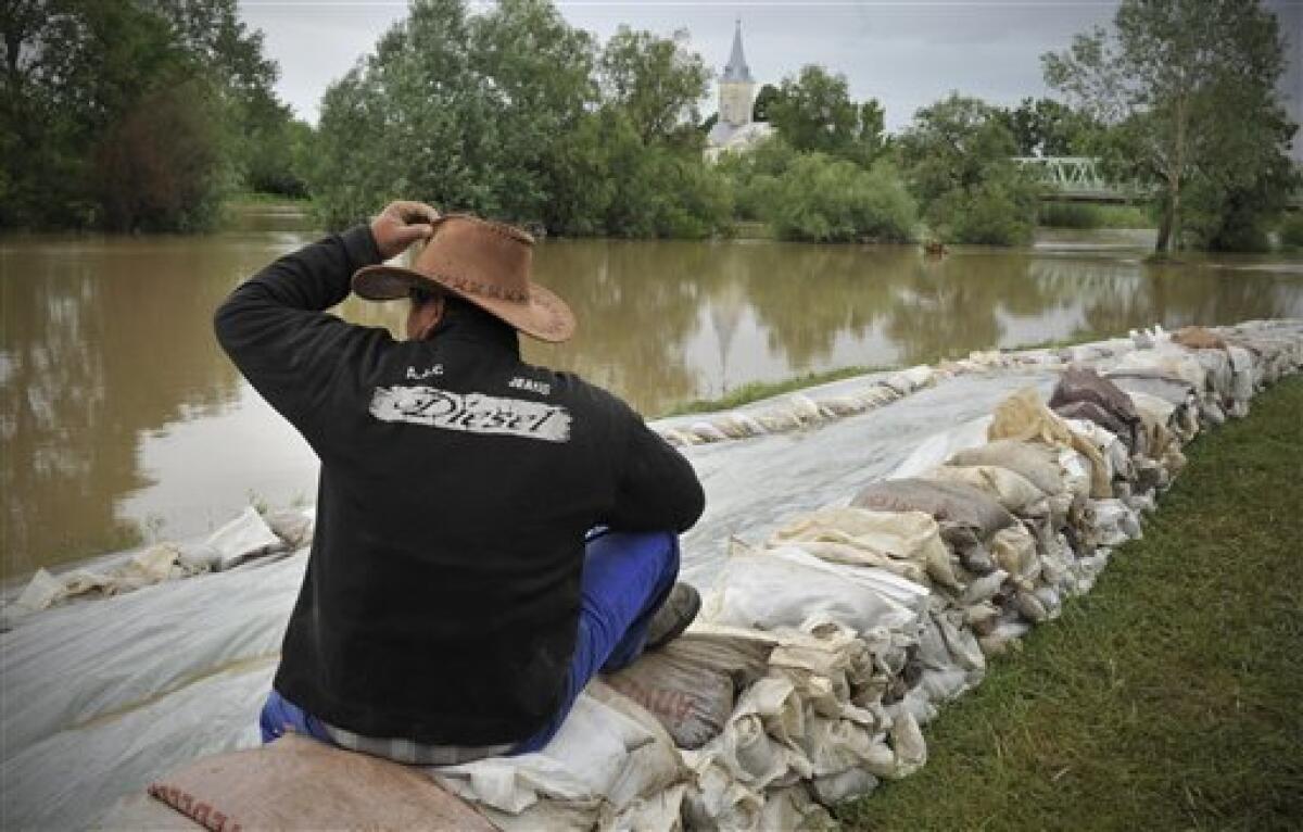 A villager looks at the River Hernad from a row of sandbags protecting the broken dike of the village of Gesztely, northeastern Hungary, Tuesday, May 18, 2010. Several swollen rivers causing floods throughout Hungary, while roads remain closed due to the unusual wet weather and heavy rains. (AP Photo/Bela Szandelszky)