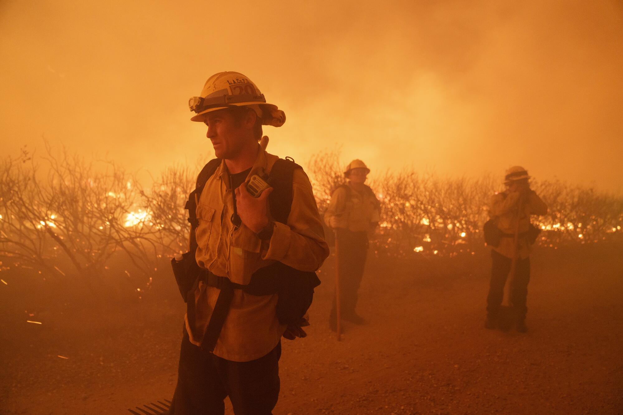 Firefighters work against the advancing Post Fire on Sunday.