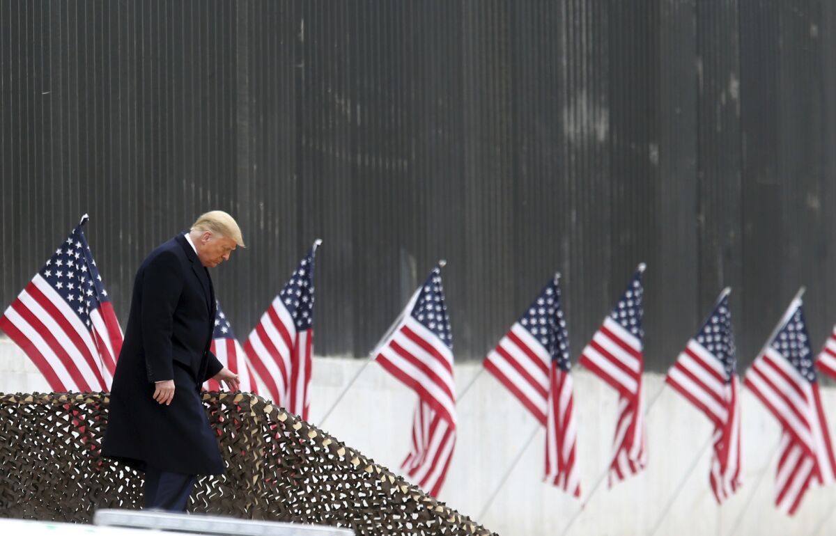 President Donald Trump walks down the steps before a speech near a section of the U.S.-Mexico border wall, in Alamo, Texas.