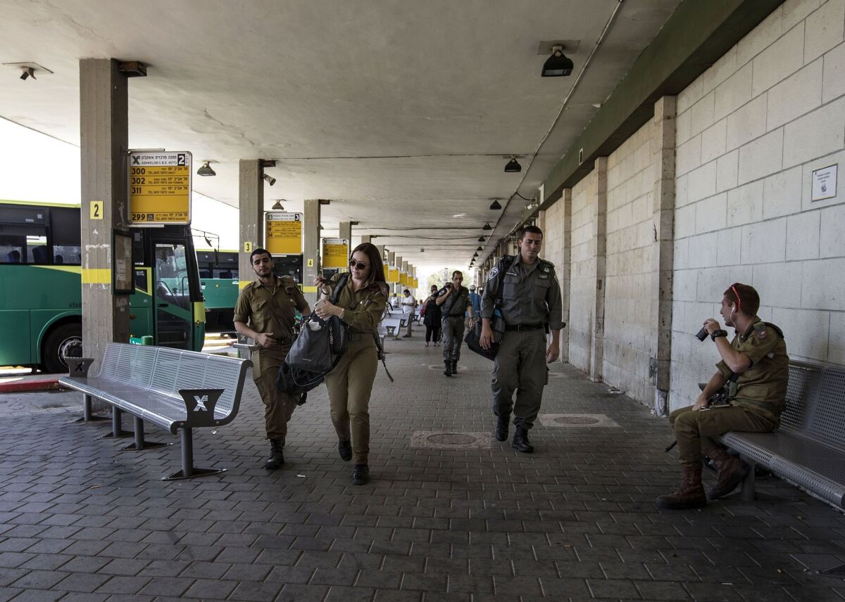 Israeli soldiers walk as a siren sounds during an army drill simulating a rocket attack on Israel, at a central bus station, in the southern city of Ashkelon on June 2.